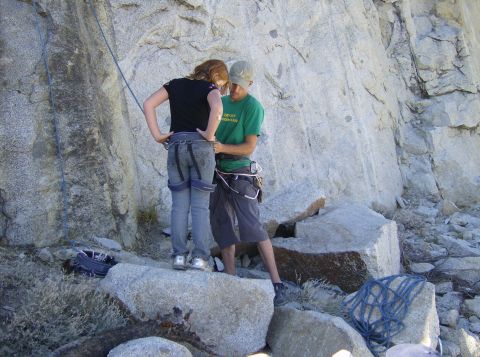 1986 Ford Bronco - A climber is helped into their harness before ascending a large rock face.