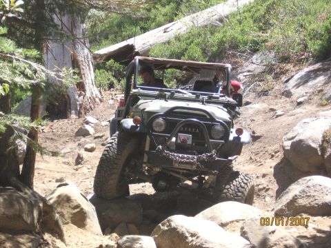 1994 Ford Bronco - Toyota Land Cruiser FJ40 tackles a challenging off-road trail with large rocks.