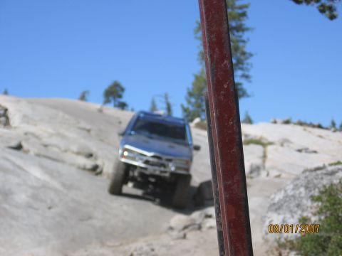 1994 Ford Bronco - A blue SUV navigates a steep, rocky terrain under a clear blue sky, with a date stamp of 09/01/2007 visible.