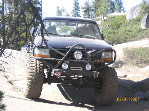 1994 Ford Bronco - Modified 1994 Ford Bronco navigating a rocky trail with another vehicle in the background.