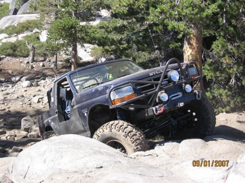 1994 Ford Bronco - This 1994 Ford Bronco is shown off-roading on a rocky trail, equipped with a heavy-duty front bumper and winch.