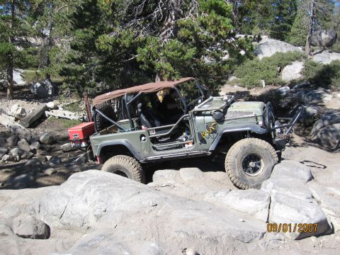 1994 Ford Bronco - This off-road vehicle navigates a challenging rocky path, its build evident against the natural landscape.