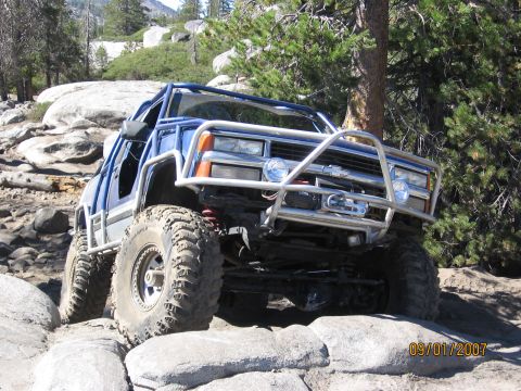 1994 Ford Bronco - This heavily modified off-road vehicle navigates a challenging rocky trail.