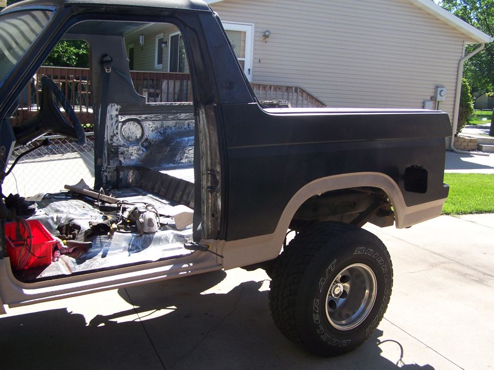 Black-painted SUV body shell with bed area on a driveway