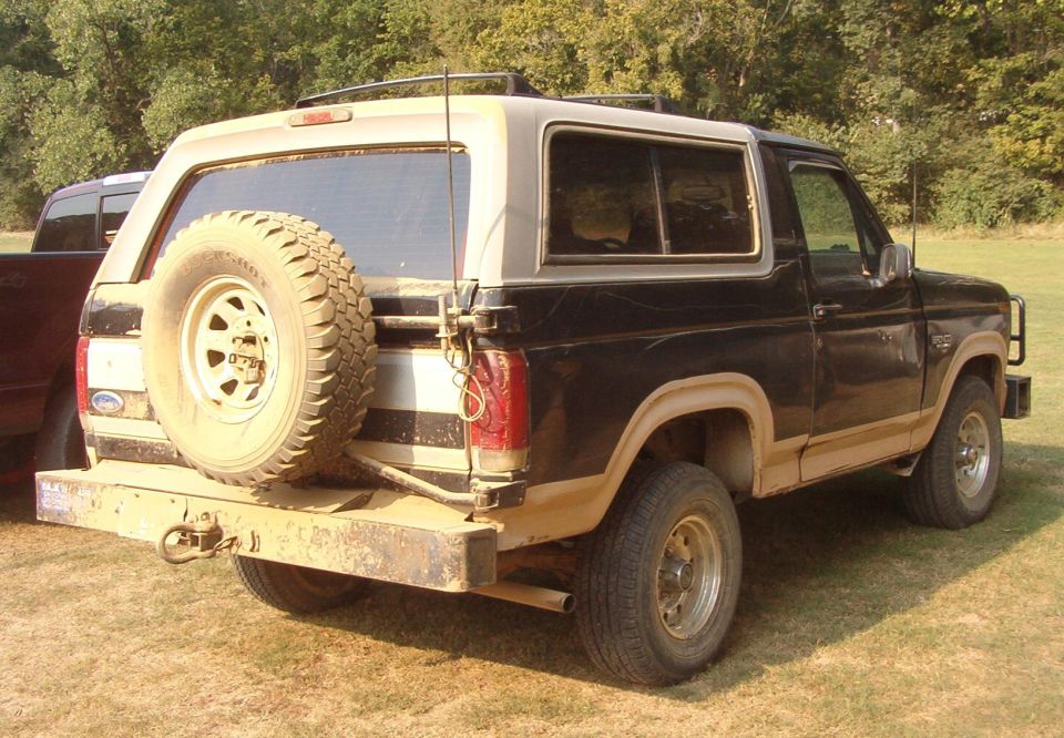 Rear quarter of a black and tan Ford Bronco with rear spare tire