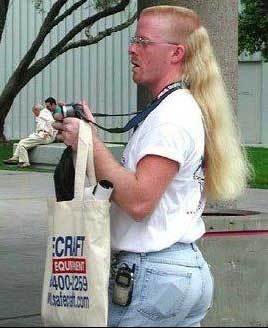 1971 Ford Ranchero - A man with a distinctive mullet hairstyle holds a camera and a tote bag with visible text.