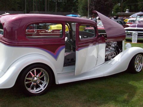 1997 Ford Mustang - Customized hot rod sedan with a two-tone paint job and exposed engine is displayed outdoors.