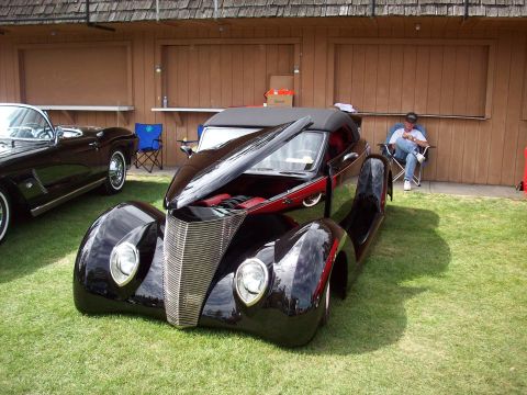 1997 Ford Mustang - A custom hot rod is displayed with its hood open, parked on grass beside another vehicle.