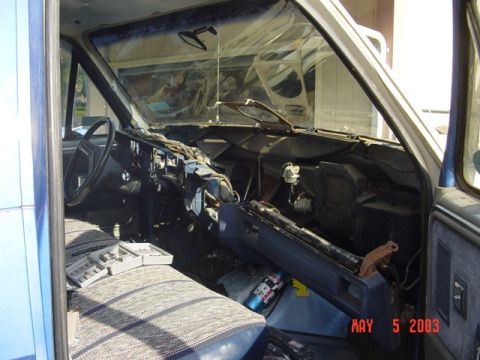1989 Ford Bronco - The interior of a truck is shown with the dashboard disassembled, revealing wiring and components.