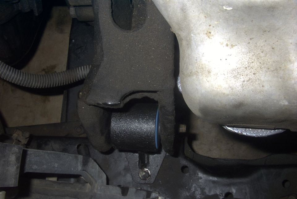 Black motor mount with blue insert attached to vehicle frame