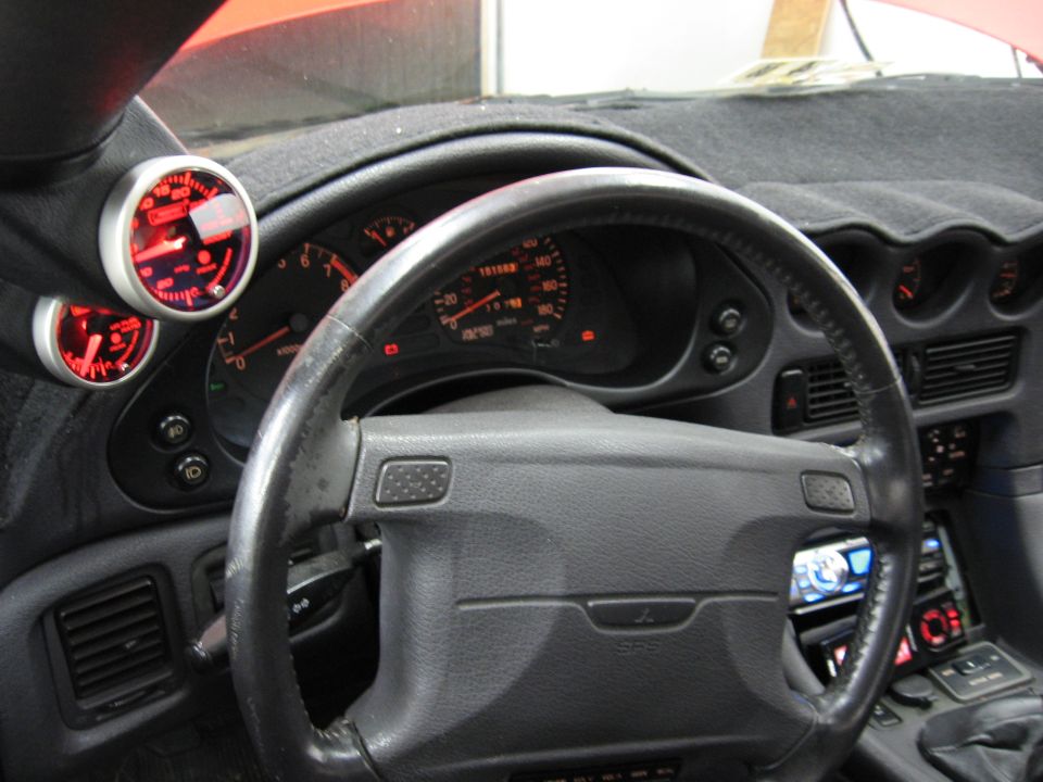 1991 Mitsubishi 3000GT interior showing dashboard, steering wheel, and aftermarket gauges