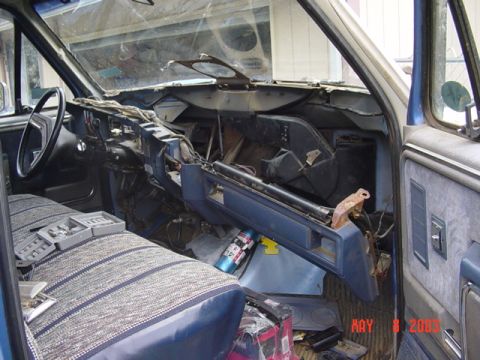 1989 Ford Bronco - The interior of a vehicle shows significant disassembly, with wires and dashboard parts exposed.