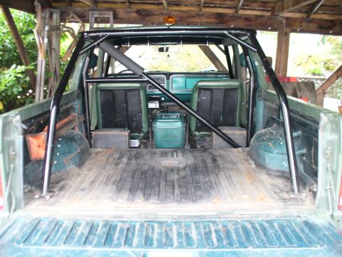 1978 Ford Bronco - Interior view of a green SUV, showing the bed and a prominent roll cage structure.