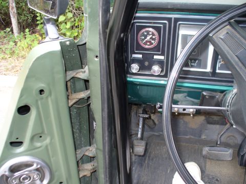 1978 Ford Bronco - Interior view of a green vehicle, focusing on the dashboard and door mechanism.