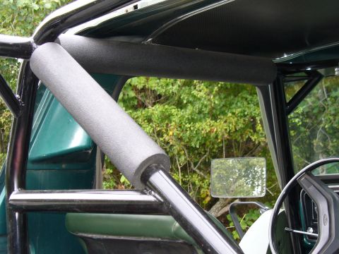 1978 Ford Bronco - Interior view of a green 1978 Ford Bronco, showing the roll cage and dashboard details.