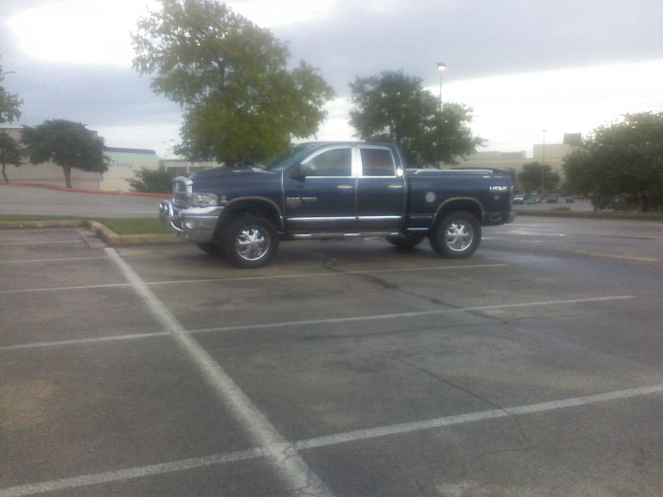 Dark blue Dodge Ram pickup truck parked in a lot, side view