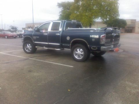 1995 Ford Bronco - A dark blue pickup truck with chrome trim and "HEMI" badging is parked in a lot.
