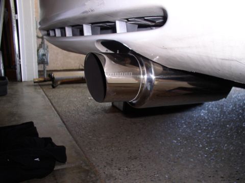 1994 Ford Probe - Close-up of a shiny exhaust pipe, showing a portion of the vehicle's rear bumper.