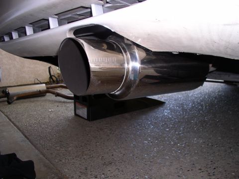 1994 Ford Probe - Close-up of a chrome exhaust tip with 'Megan' branding, part of a vehicle's exhaust system.