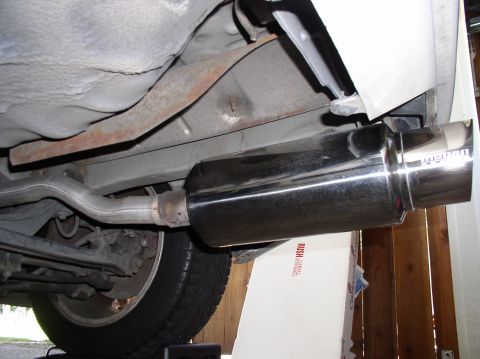 1994 Ford Probe - Aftermarket exhaust muffler and pipe shown from underneath a vehicle.