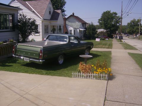 1970 Ford Ranchero - Green 1970 Ford Ranchero with a tonneau cover parked in front of a residential house.