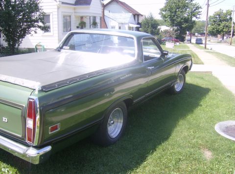1970 Ford Ranchero - A green pickup truck is parked on a residential street with a house in the background.