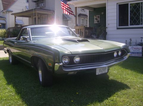 1970 Ford Ranchero - A green 1970 Ford Ranchero with a hood scoop sits on a lawn in front of a house.