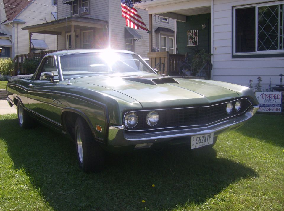 Metallic green Ford Ranchero front three-quarter view on a lawn with hood scoops and mag wheels