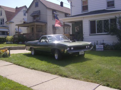 1970 Ford Ranchero - A green 1970 Ford Ranchero is parked on a grassy lawn in front of a house.