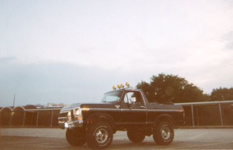 1978 Ford Bronco - A black 1978 Ford Bronco is parked outside with a cloudy sky overhead.