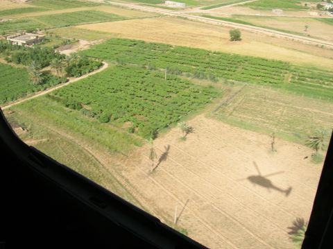 1996 Ford Bronco - Aerial view shows a helicopter's shadow cast upon a field, with agricultural land and structures visible.