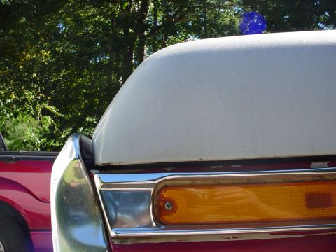 1978 Ford Bronco - Detail of a vehicle's rear lighting assembly, with another vehicle visible in the background.