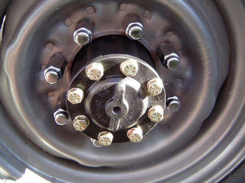 Close-up of a heavy-duty wheel hub with multiple lug nuts and bolts