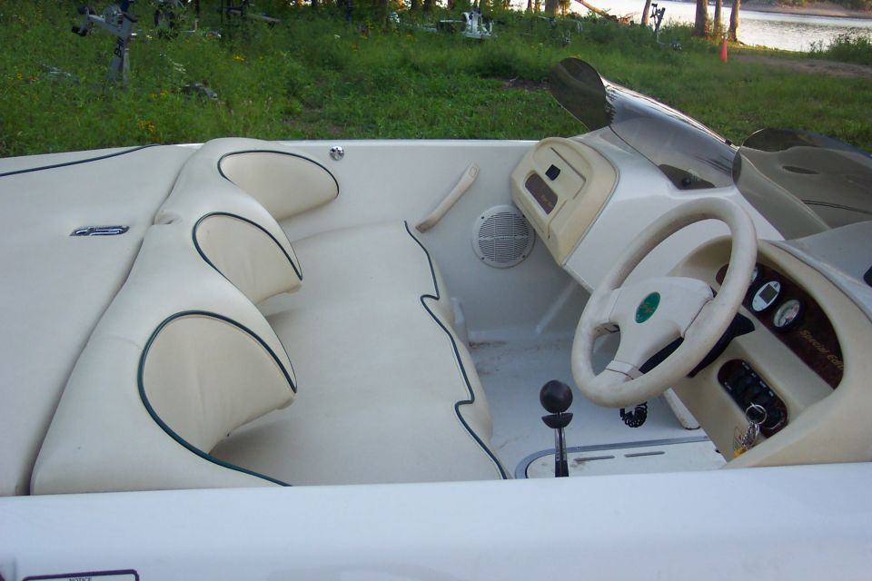 Tan interior of a runabout boat with helm, steering wheel and bench seats