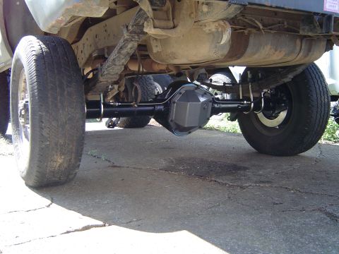 1978 Ford Bronco - The photo shows the rear axle assembly and suspension of a vehicle, with another vehicle in the background.