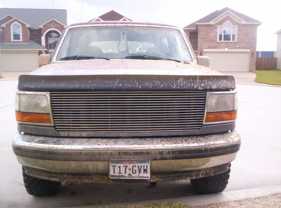 1992 Ford Bronco front view, grille and bumper covered in dirt