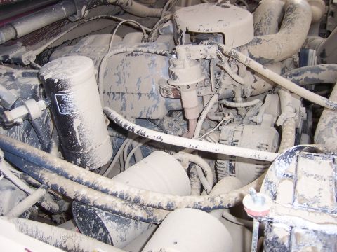 1991 Ford Bronco - Engine bay components are heavily coated in dust, obscuring details and year identification.
