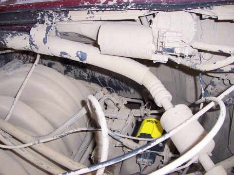 1991 Ford Bronco - Close-up of engine bay components heavily coated in dust, a yellow ACCEL ignition part.