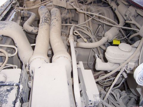 1991 Ford Bronco - Dust covers most of the engine bay components, including intake tubes and the brake fluid reservoir.
