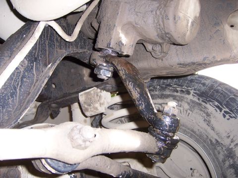 1991 Ford Bronco - Underside view of a vehicle's suspension system, showing various mechanical components covered in grime.