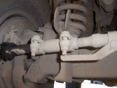 1991 Ford Bronco - Detail of the steering linkage and suspension system, including a coil spring, on a vehicle.