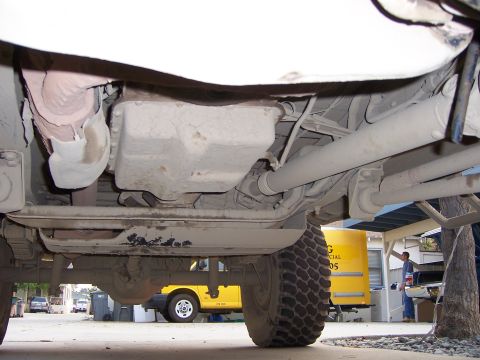 1991 Ford Bronco - Undercarriage view of a vehicle, with other vehicles and a person in the background.