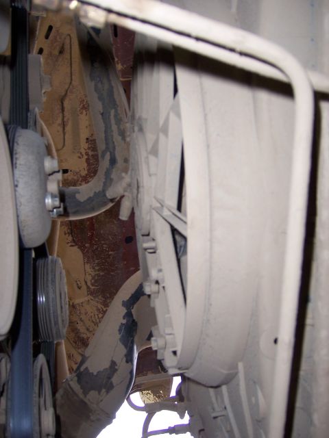 1991 Ford Bronco - Close-up view of the engine fan and belts, showing dust accumulation on the mechanical parts.