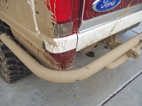1991 Ford Bronco - The rear of a mud-splattered 1991 Ford Bronco, showing its bumper and taillight.