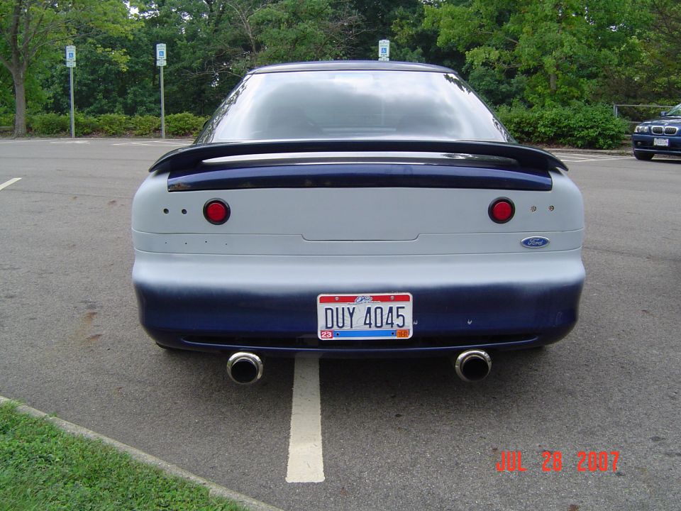 Rear of dark blue coupe with spoiler, dual round exhaust tips, Ohio plate DUY 4045