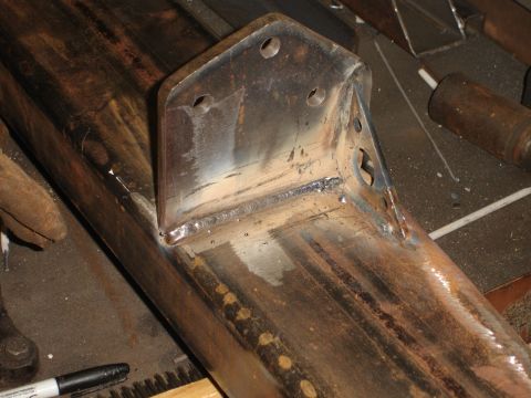 1989 Ford Bronco - A metal bracket is welded onto a tubular frame component, showing signs of fabrication and repair.