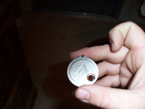 2003 Ford Ranger - A spark plug gap tool is shown, with text and a hole visible on its surface.