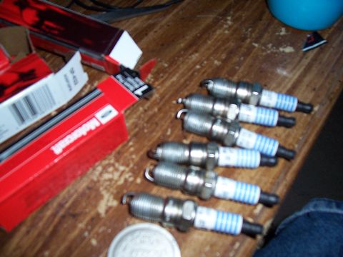 2003 Ford Ranger - A set of Motorcraft spark plugs are displayed on a wooden table, with their packaging nearby.