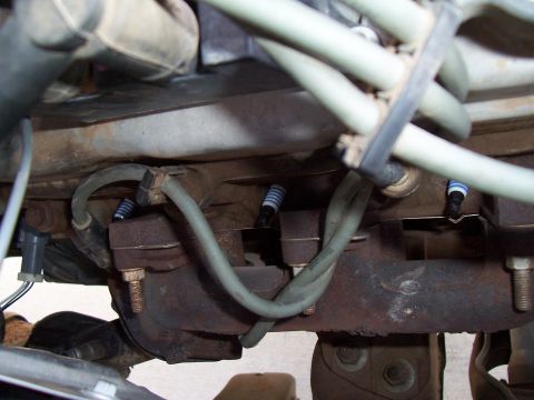 2003 Ford Ranger - Spark plugs and exhaust manifold detail on an engine.