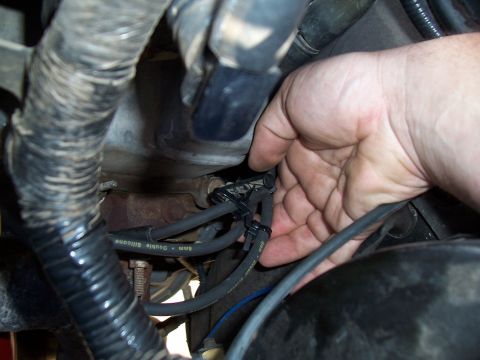 2003 Ford Ranger - Close-up of a hand working on spark plug wires in an engine bay. The wires are labeled "6mm Double Silicone".